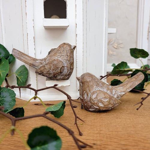 Faux wood bird figurines with an embossed leaf pattern.