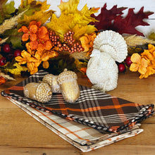 Load image into Gallery viewer, Fall foliage vignette with a rustic white turkey figurine, fall plaid tea towels and chippy gold cement acorns.
