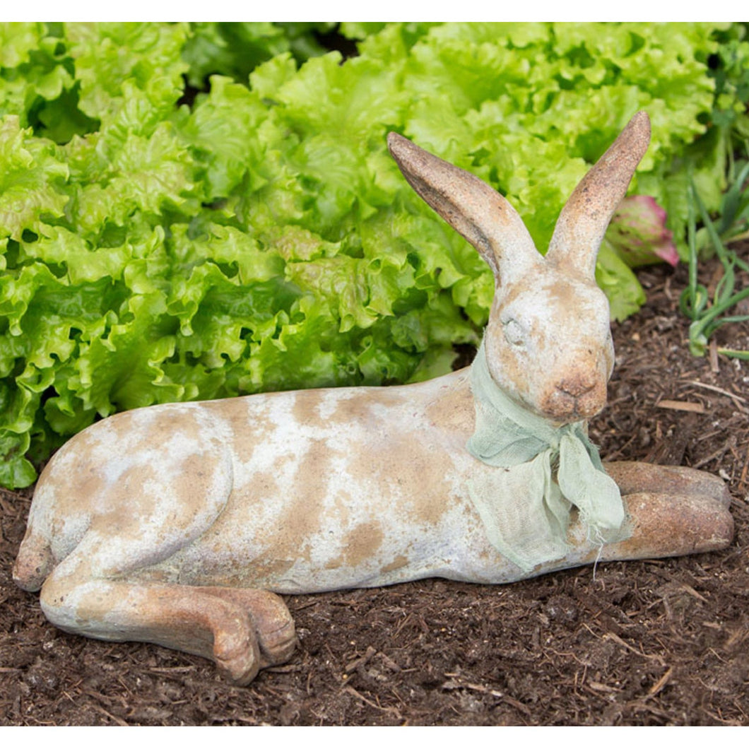 Weathered cottage rabbit laying down statue.