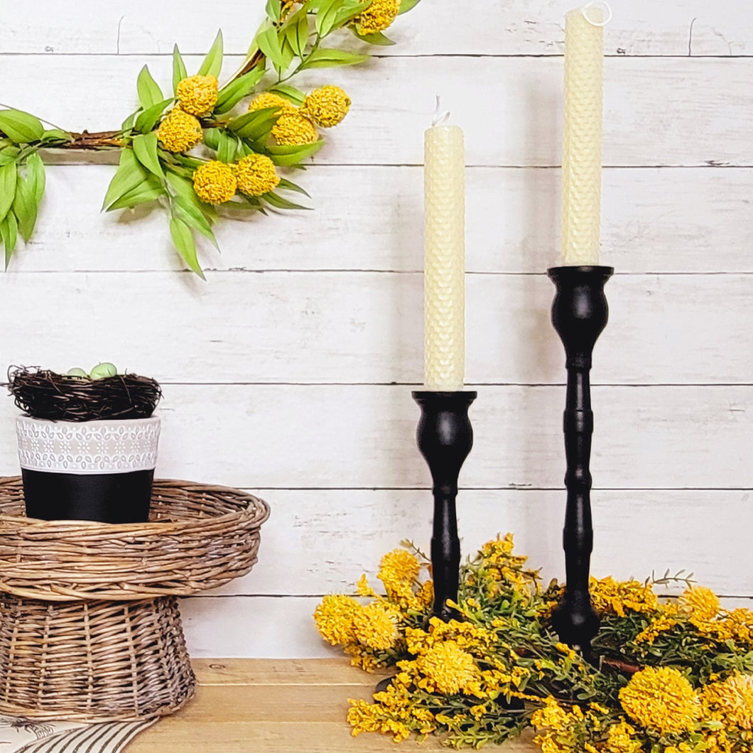 Curved black metal taper candlestick holders with natural beeswax candles