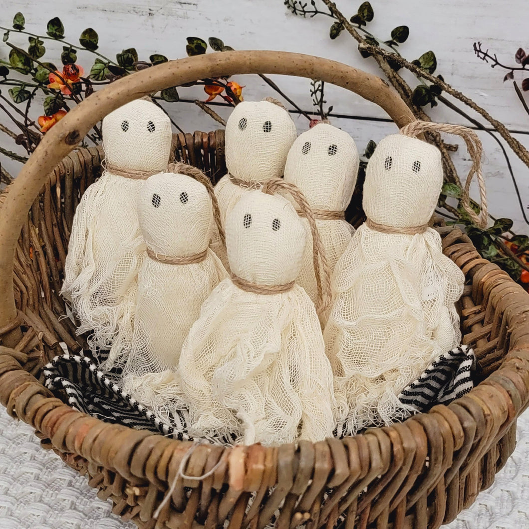 Rustic wicker basket filled with primitive fabric ghost ornaments.