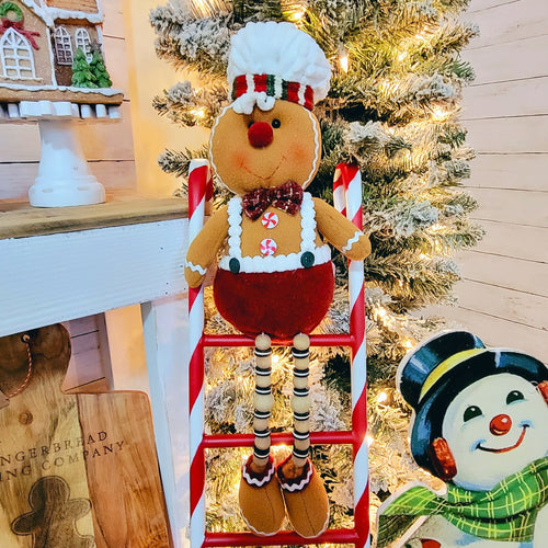 22 inch tall plush gingerbread mann doll with wiggly beaded legs sitting on a candy cane ladder.