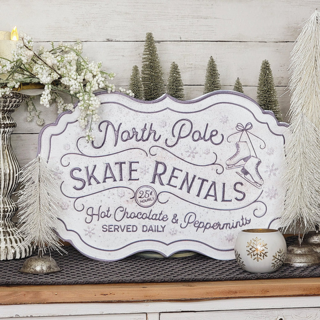 Winter vignette with snowy tress and a North Pole Skate Rental metal sign.