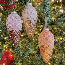 Load image into Gallery viewer, Amber glass pinecone ornaments hung from a Christmas tree.
