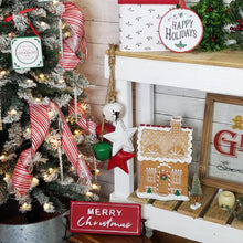 Load image into Gallery viewer, Vintage inspired Christmas display with hanging metal stars and sleigh bells, gingerbread house, and candy cane decorated tree
