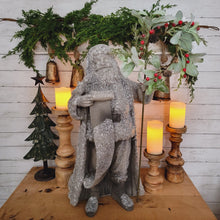 Load image into Gallery viewer, Snowy glittered large Santa statue holding a lambs ear and berry wreath.
