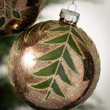 Load image into Gallery viewer, Shimmery botanical leaves on a golden glass ornament.
