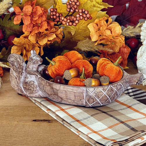 faux carved squirrel acorn shaped bowl filled with mini pumpkins.