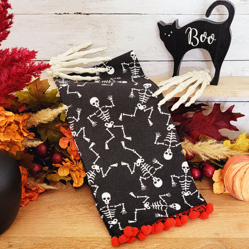 Dancing skeleton Halloween tea towel with orange pom pom trim.