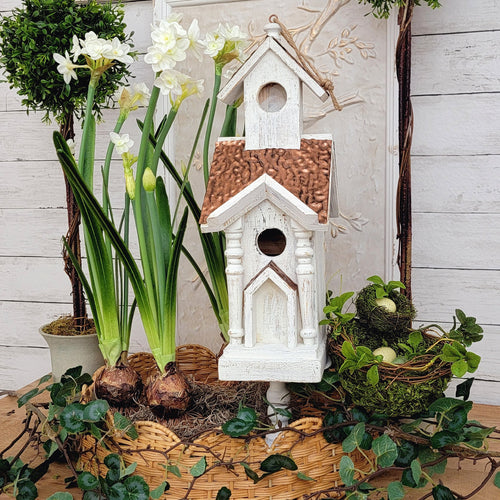 Rustic-white wood and copper roof chapel style outdoor birdhouse with daffodil bulbs. 