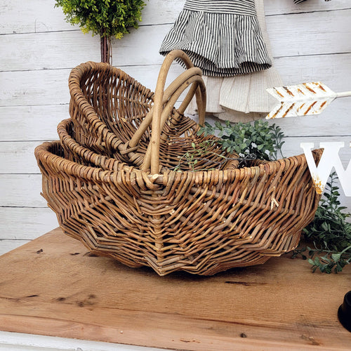 Natural willow nesting baskets with a curved signle handle.