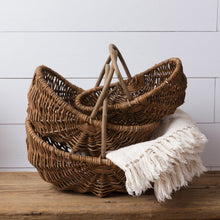 Load image into Gallery viewer, Nesting willow baskets displaying a throw blanket.
