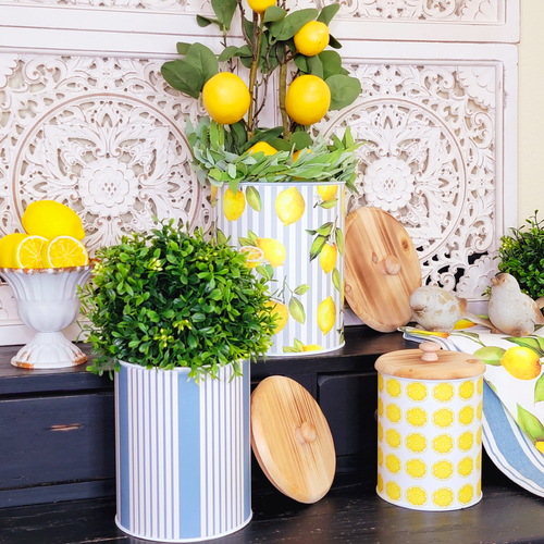 French country lemon and blue ticking stripe metal canisters filled with greenery on a side table