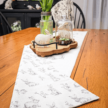 Load image into Gallery viewer, Easter tabvlescape with a neutral rabbit and wildflowers reversible beige table runner with an ornate wood tray centerpiece.
