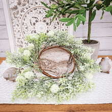 Load image into Gallery viewer, Off white billy button candle ring leaning on an ornate cement-like pedestal displayed on a side table with weathered bird figurines.
