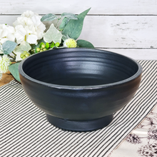 Load image into Gallery viewer, Matte black ceramic pottery decorative bowl displayed as tabletop home decor on a sidetable
