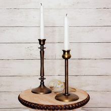 Load image into Gallery viewer, Antique style brass taper candlestick holder set on top of a beaded wood pedestal with a weathered bird figurine
