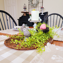 Load image into Gallery viewer, Willow tray centerpiece with artificial greenery bird figurines pink faux easter eggs in a birds nest distressed metal pedestal with a flameless pillar real wax candle on a tan and linen plaid table runner
