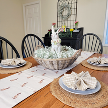 Load image into Gallery viewer, Easter Table Setting Brown Rabbit Table Runner wicker basket centerpiece with a babies breath wreath and large white bunny statue in the center round jute placemats and tan gingham napkins
