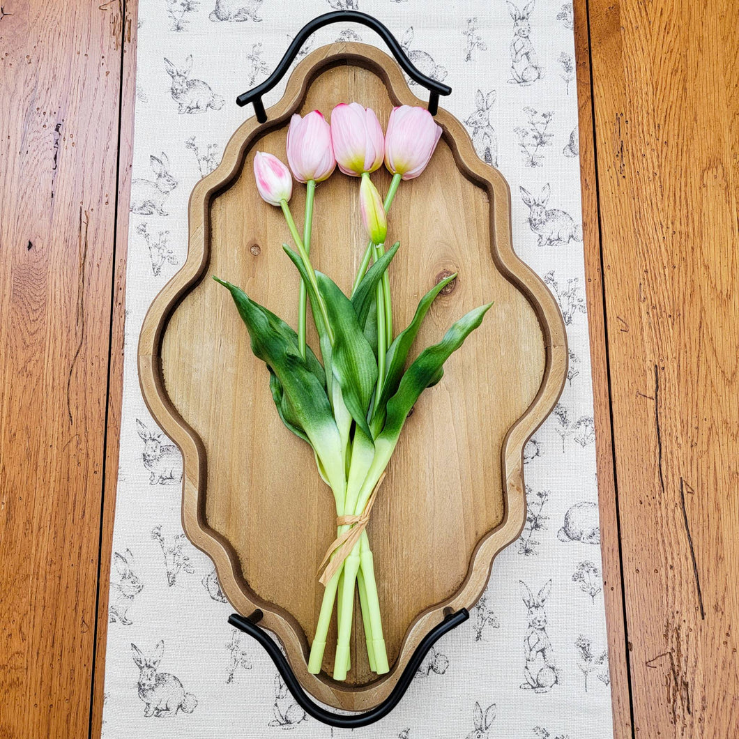 Pink real touch tulip bundle laying on an ornate wood tray.