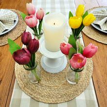 Load image into Gallery viewer, Artificial Real Feel Tulips in milk bottle Glass Vases around a flameless candle on top of an antique style metal pedestal with a round jute placemat and tan plaid table runner
