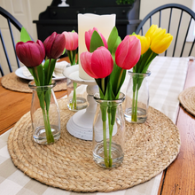 Load image into Gallery viewer, Artificial Real Feel Tulips in milk bottle Glass Vases around a flameless candle on a chippy white metal pillar holder centerpiece on a round jute placemat with a tan buffalo plaid table runner
